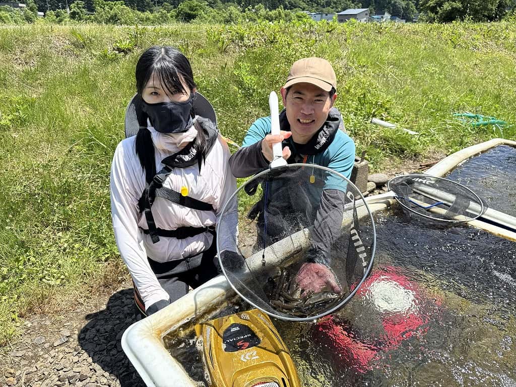 オトリ鮎の入ったタモを見せる様子