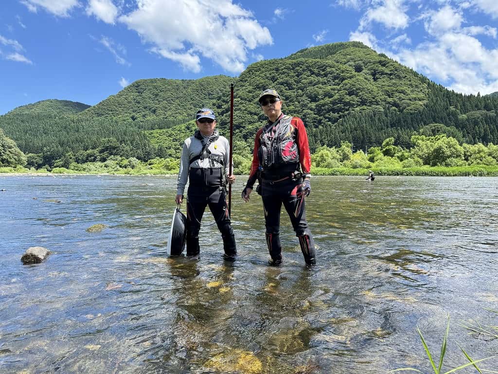 快晴の阿仁川で並ぶ2人の鮎釣り師