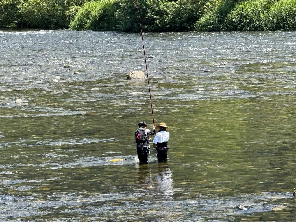 指導を受けながら竿を出す後ろ姿